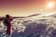 Tourist looking through binoculars on the snowy slopes of the Ca