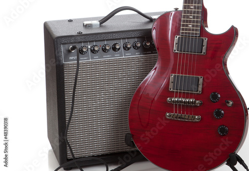 Photo: An electric guitar with a black amp on a white background An electric guitar with a black amp on a white background