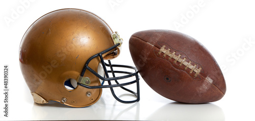 Photo: A retro gold football helmet and football on a white background A retro gold football helmet and football on a white background