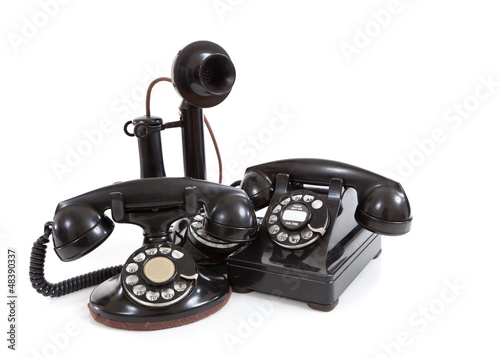 Photo: A group of vintage telephones on a white background A group of vintage telephones on a white background