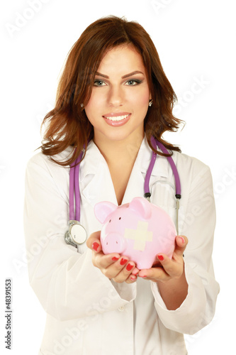 Photo: A doctor holding piggy box with a stethoscope, close-up A doctor holding piggy box with a stethoscope, close-up