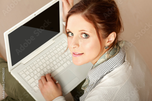 Photo: Portrait of a lovely young lady using a laptop. Portrait of a lovely young lady using a laptop.