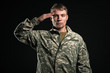 Military young man salutes. Studio portrait.