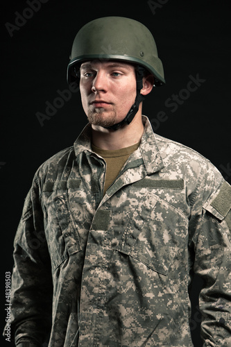Photo: Military young man wearing helmet. Studio portrait. Military young man wearing helmet. Studio portrait.
