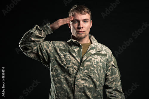 Photo: Military young man salutes. Studio portrait. Military young man salutes. Studio portrait.