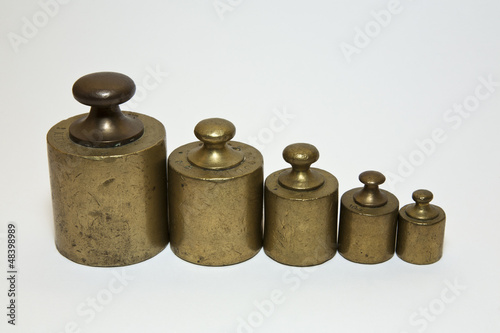 Photo: Five old calibration weights in a row and isolated on white Five old calibration weights in a row and isolated on white