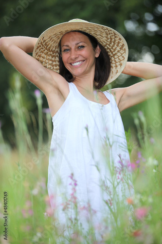 Photo: Woman with hat in the field Woman with hat in the field