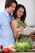 Couple watching cookbook in a kitchen