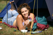Woman laying by her tent reading