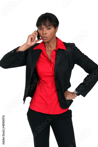 Photo: Serious businesswoman taking a call on a cellphone Serious businesswoman taking a call on a cellphone
