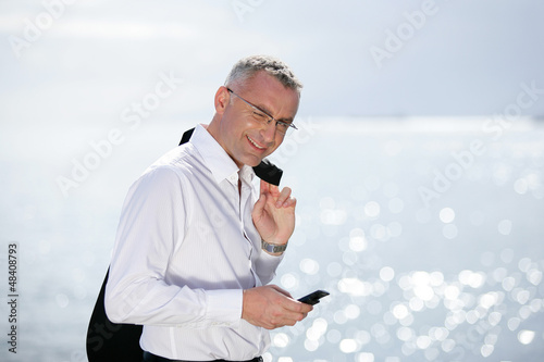 Photo: businessman on vacation talking on his cell businessman on vacation talking on his cell