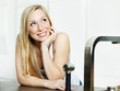 Relaxed young woman standing at the kitchen counter