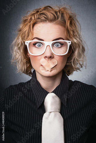Photo: Woman with adhesive bandage over her mouth Woman with adhesive bandage over her mouth