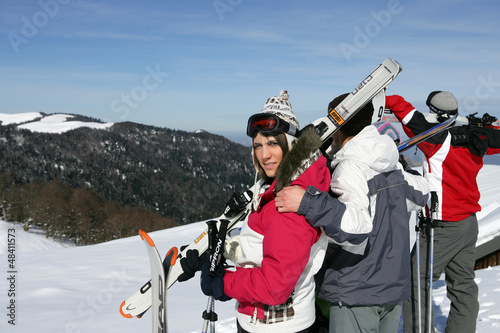 Photo: Group of young skiers standing atop a mountain Group of young skiers standing atop a mountain