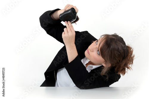 Photo: Woman looking into her coin purse for money Woman looking into her coin purse for money