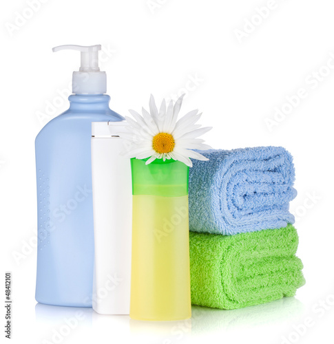 Photo: Shampoo and gel bottles with towels and flower Shampoo and gel bottles with towels and flower