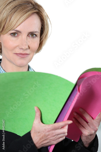 Photo: Woman holding brightly colored files Woman holding brightly colored files