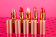 Lipsticks on table on pink background