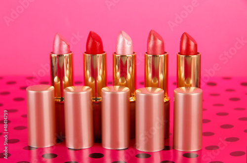 Photo: Lipsticks on table on pink background Lipsticks on table on pink background