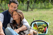 Couple sat by basket full of grapes