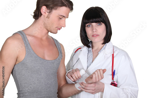 Photo: Doctor wrapping gauze around a patient's wrist Doctor wrapping gauze around a patient's wrist