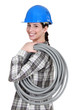 Tradeswoman carrying corrugated tubing