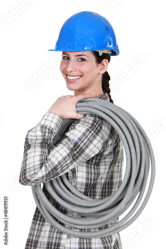 Photo: Tradeswoman carrying corrugated tubing Tradeswoman carrying corrugated tubing