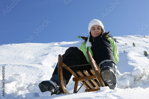 Photo: Girl on a sled in mountain Girl on a sled in mountain