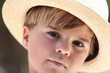little boy wearing a straw hat