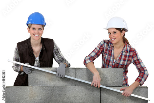 Photo: Female construction workers lifting a bar Female construction workers lifting a bar