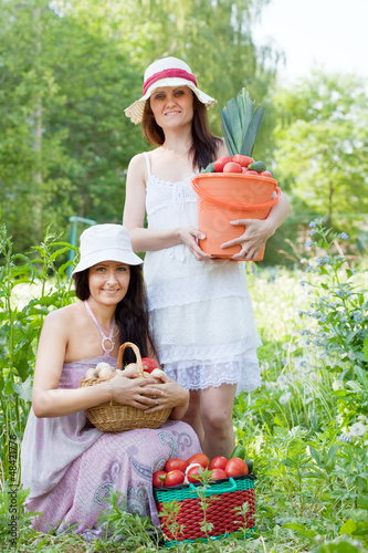 Photo: women with harvested vegetables in garden women with harvested vegetables in garden