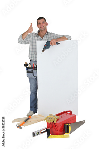 Photo: Approving tradesman posing with a blank sign and his tools Approving tradesman posing with a blank sign and his tools