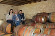 Foto: three people drinking wine in a cellar three people drinking wine in a cellar