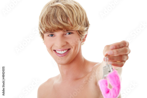 Photo: Young attractive caucasian man with pink handcuff Young attractive caucasian man with pink handcuff