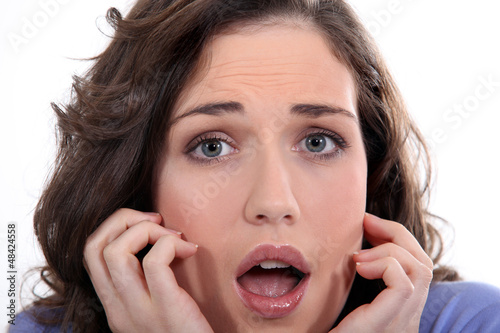 Photo: Close-up of a young woman with expression of fear Close-up of a young woman with expression of fear