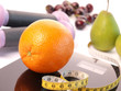 Scale with an orange fruit and a measuring tape