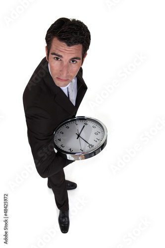 Photo: Businessman holding clock Businessman holding clock