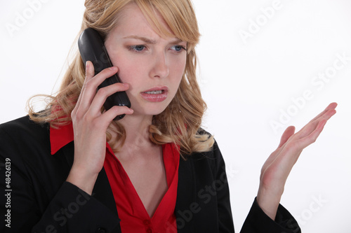 Photo: blonde on the phone looking annoyed blonde on the phone looking annoyed