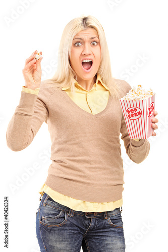 Photo: Scared blond woman holding a popcorn box and screaming Scared blond woman holding a popcorn box and screaming