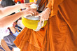Gives food offerings to a Buddhist monk