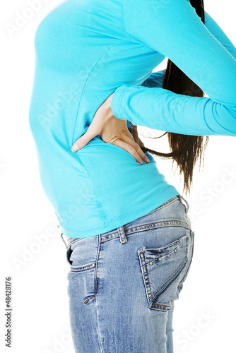 Photo: Teen student woman with back pain Teen student woman with back pain