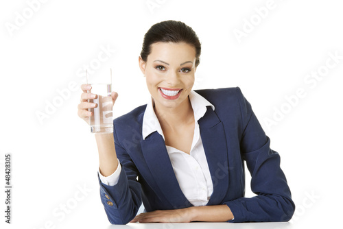 Photo: Businesswoman sitting at the desk with mineral water Businesswoman sitting at the desk with mineral water