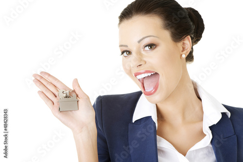 Photo: Attractive businesswoman holding a house key Attractive businesswoman holding a house key