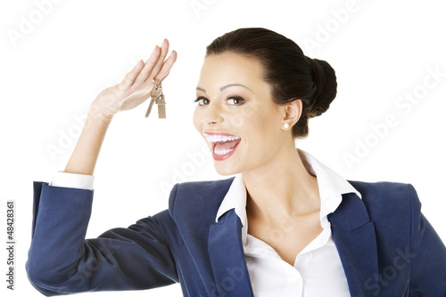 Photo: Attractive businesswoman holding a house key Attractive businesswoman holding a house key