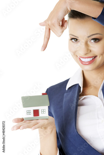 Photo: Beautiful businesswoman holding house model Beautiful businesswoman holding house model