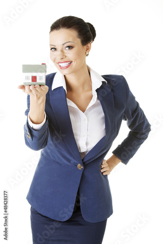 Photo: Beautiful businesswoman holding house model Beautiful businesswoman holding house model
