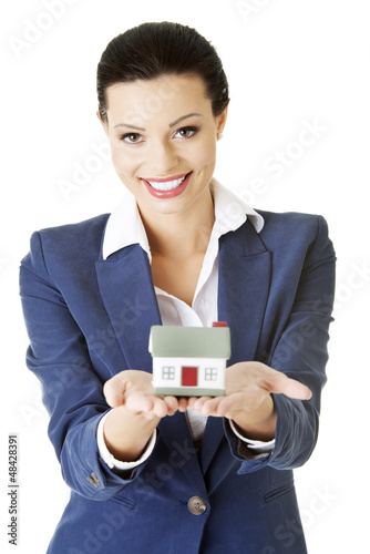 Photo: Beautiful businesswoman holding house model Beautiful businesswoman holding house model