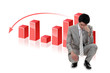 Depressed businessman in front of a bar chart