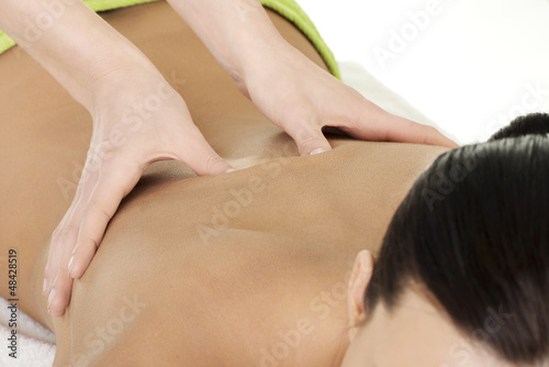 Photo: Young woman relaxing beeing massaged in spa saloon Young woman relaxing beeing massaged in spa saloon