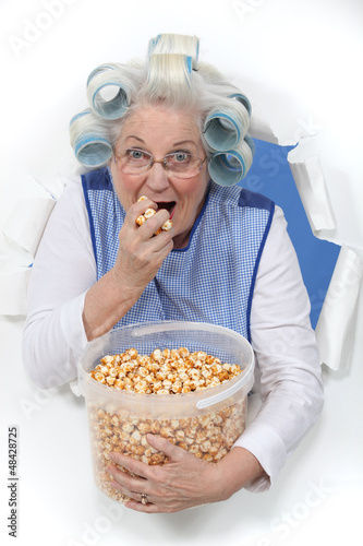 Photo: Elderly lady eating popcorn Elderly lady eating popcorn